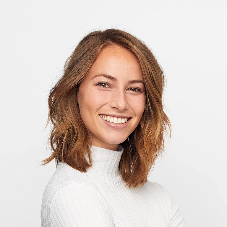 happy young woman wearing white sweater and smiling